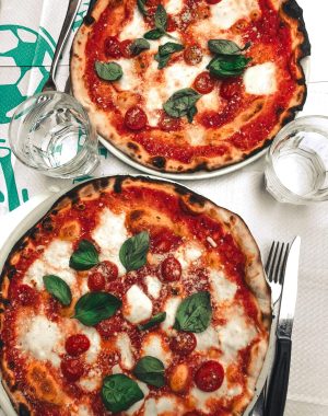 Two delicious pizzas topped with mozzarella and basil, perfect for a tasty meal.